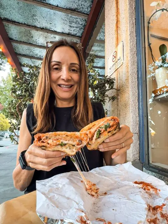 women eating a cheesy sandwich