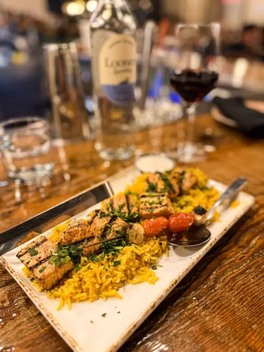 plate of rice with grill chicken kebabs on top
