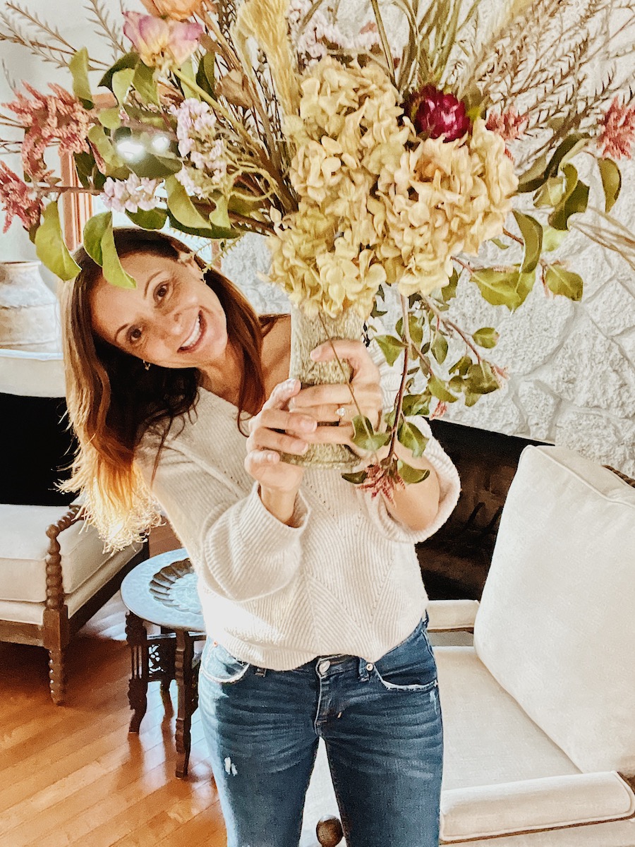 Annette White holding a flower arrangement at home
