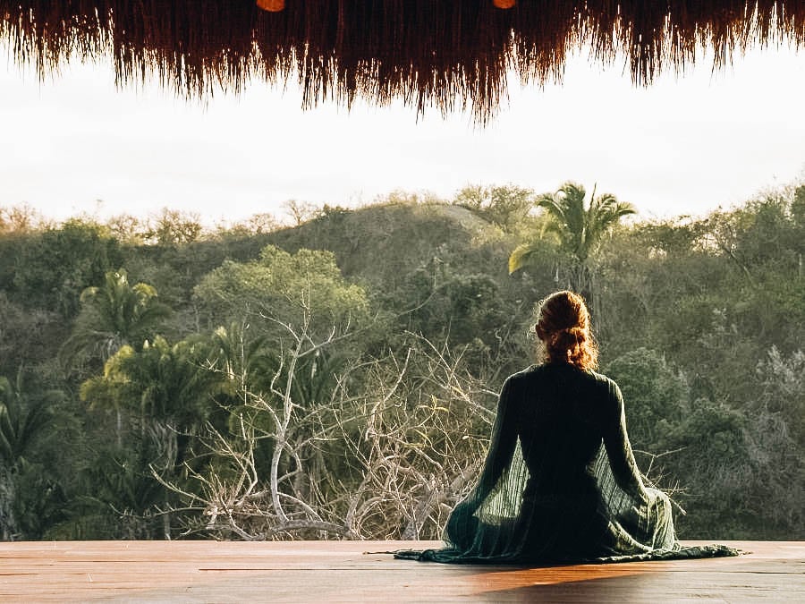 A girl meditating near a beautiful forest