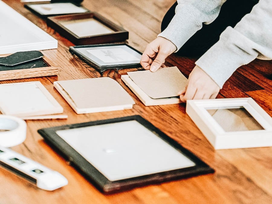 A person organizing frames and photos