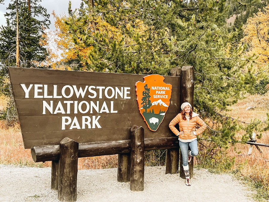 Annette beside the Yellowstone National Park sign
