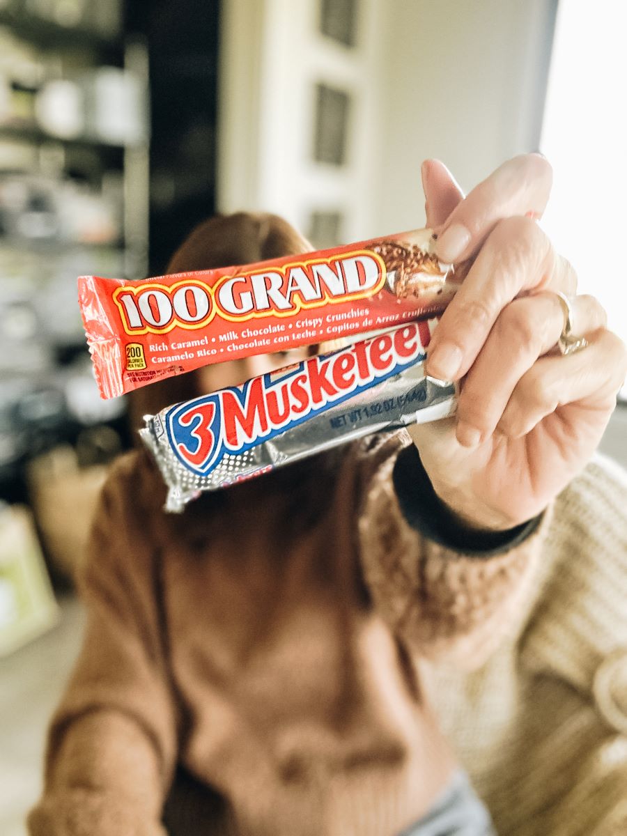 Annette holding 100 Grands and 3 Musketeers Chocolate Bars