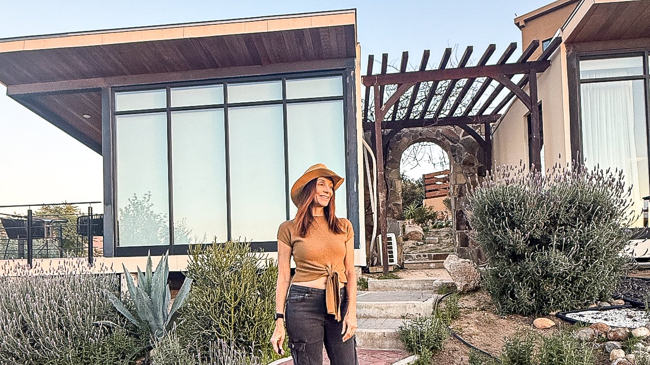 women in a hat standing in front of hotel pod