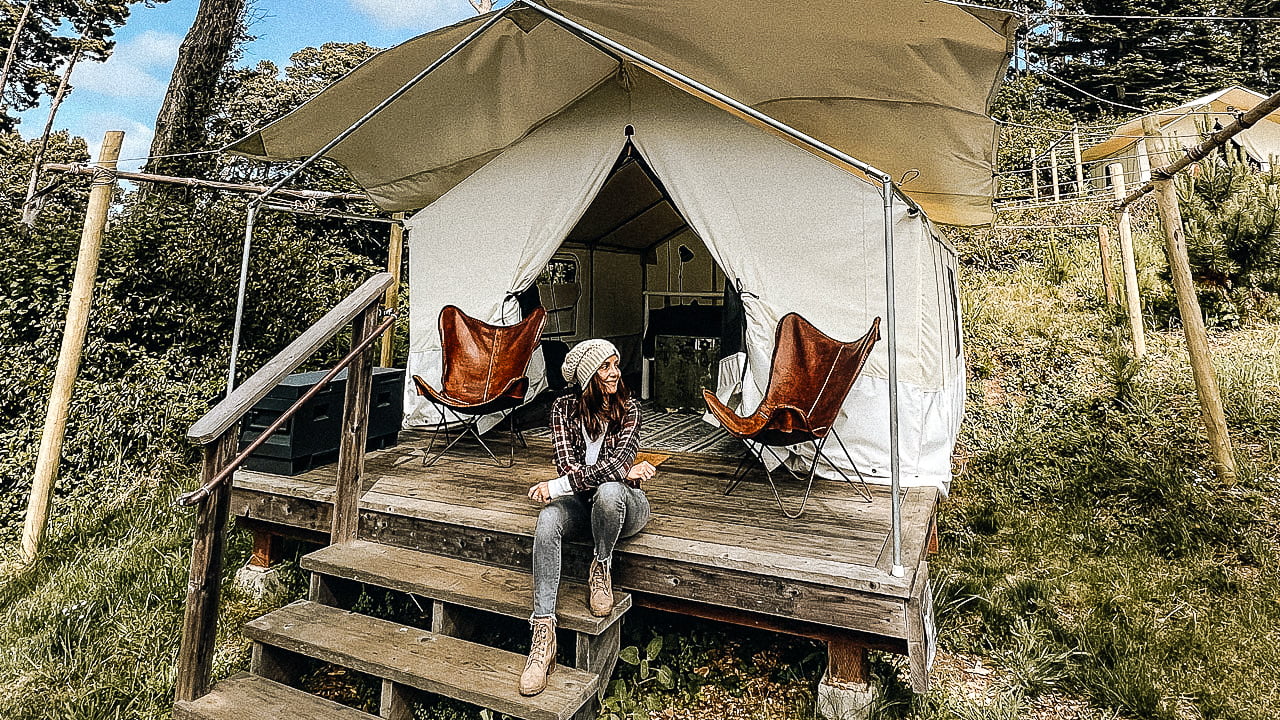 women sitting on the steps on a glamping tent