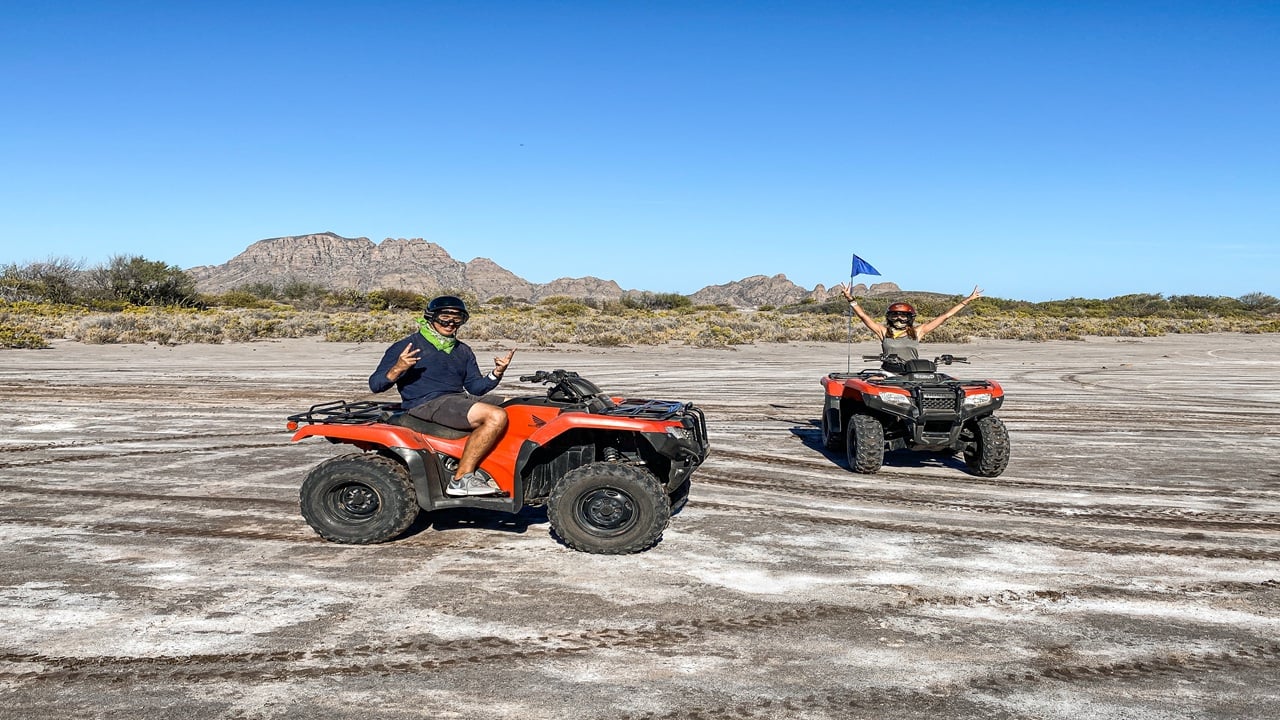 Two atvs and rides on dirt