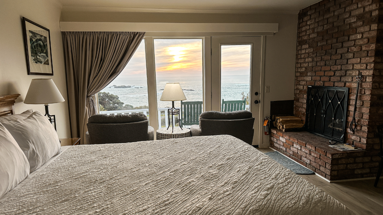 hotel room with a made bed and a sunset view